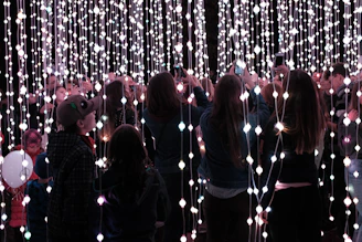 A group of friends taking photos inside the round Magic Ring photo booth with bright lighting.