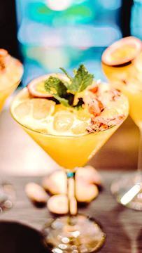 Refreshing passion fruit cocktail served in a tall glass with tropical leaves background.