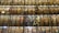 An expansive multi-level library wall filled with countless books arranged neatly on shelves. The shelves are illuminated evenly, creating a warm and inviting atmosphere. The variety of book spines display a range of colors, sizes, and materials.
