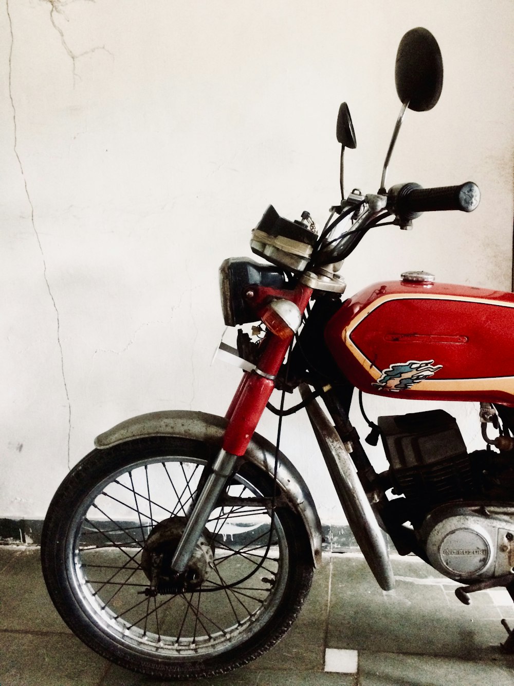 red and black motorcycle near white wall