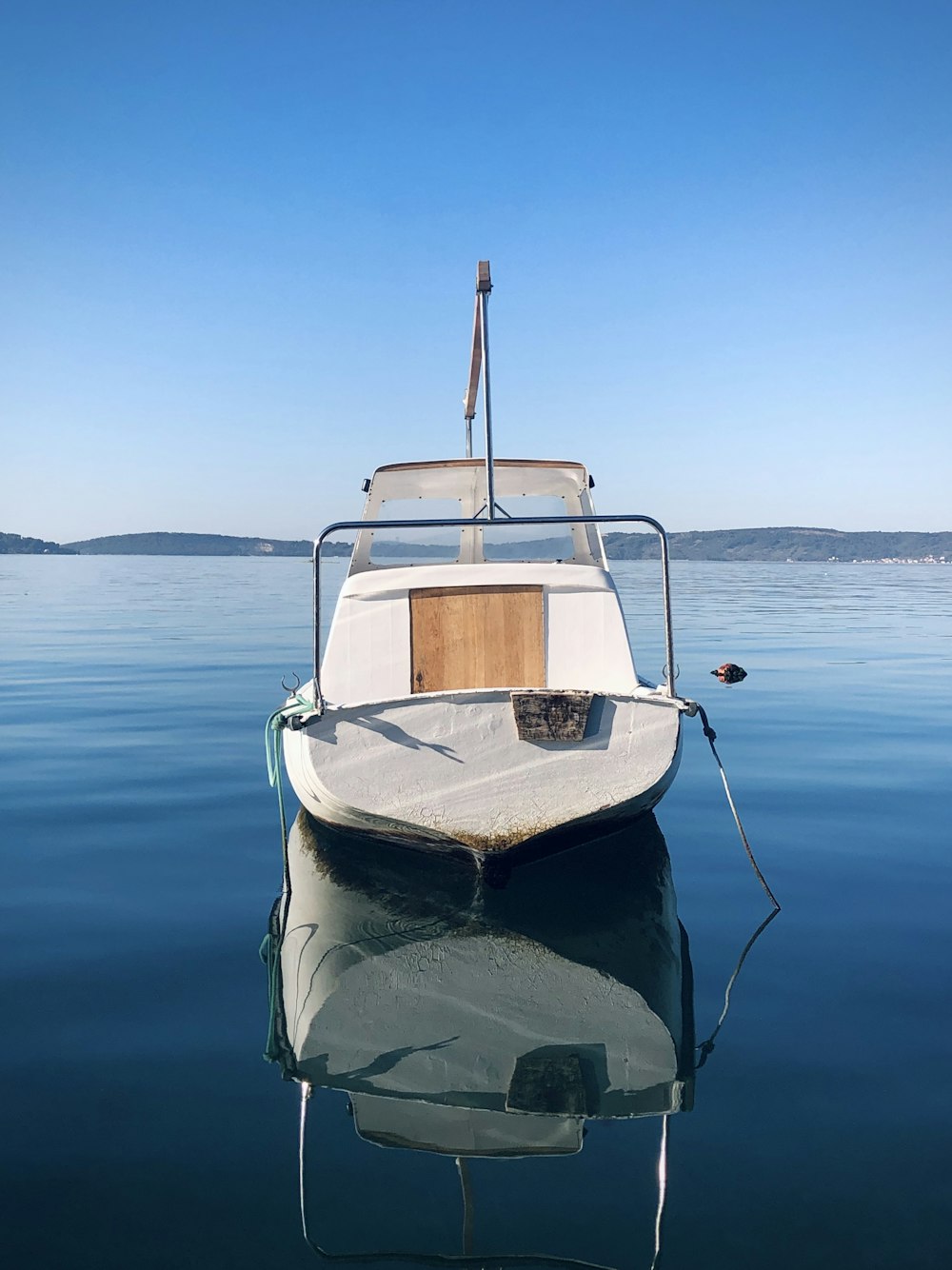 昼間の水上の白と青のボート