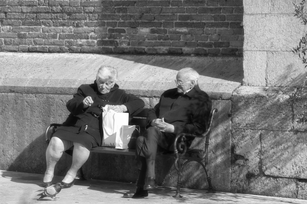 man and woman sitting on concrete bench