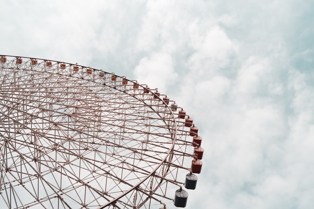 white and brown ferris wheel under white clouds and blue sky during daytime