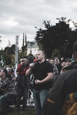 An MC engaging the audience with a microphone in hand during an outdoor event