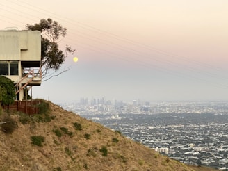 A sleek, modern Texas residential lot at sunset with clear skies and distant city lights.