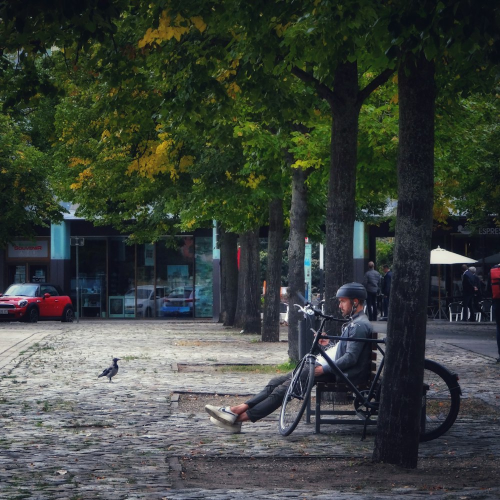 man in black jacket riding on black horse on gray concrete pavement during daytime