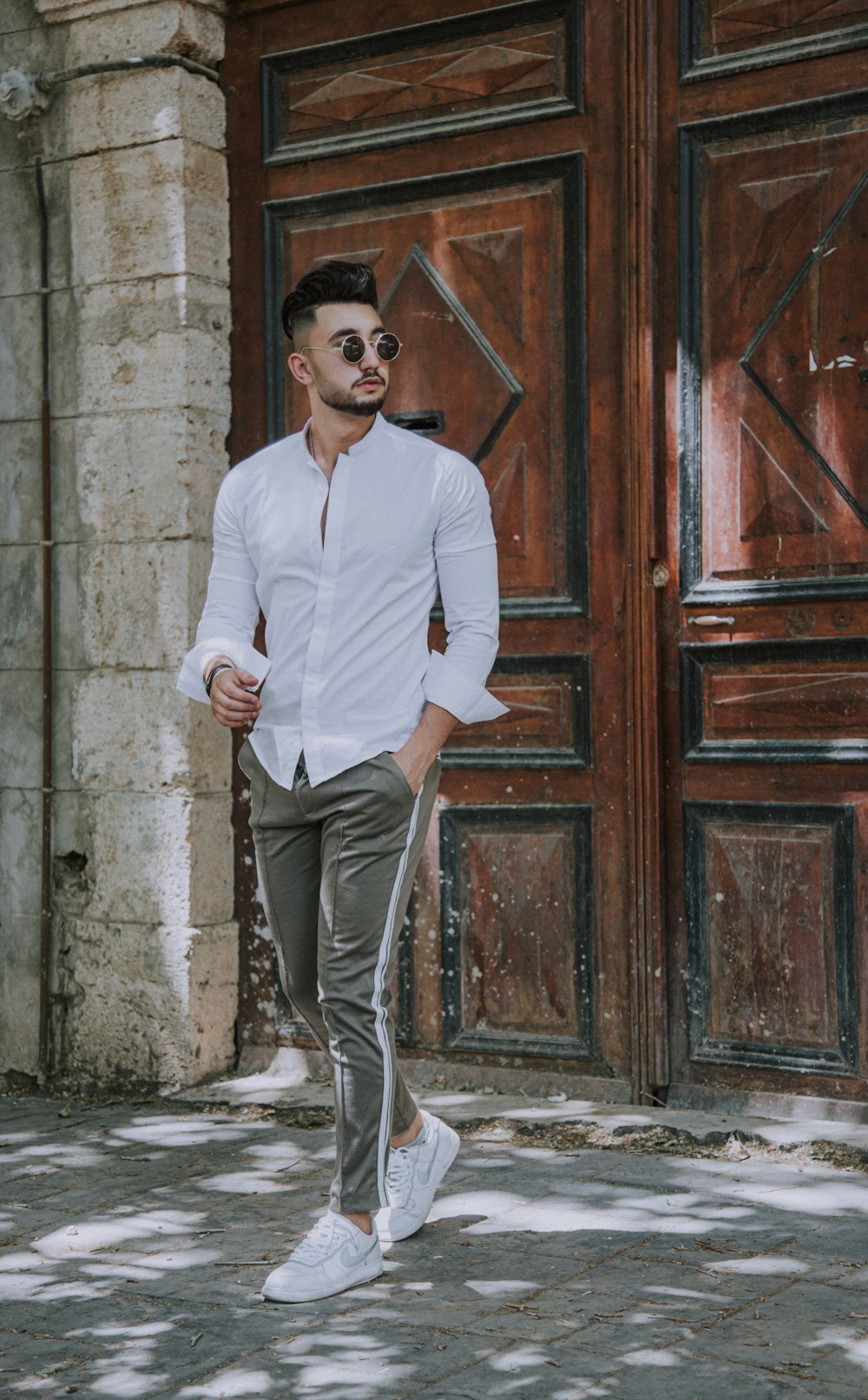 Man in white dress shirt and gray pants standing beside brown wooden door  photo – Free Grey Image on Unsplash