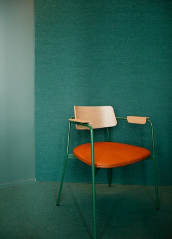 white and brown chair beside blue wall