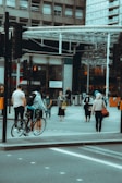 A person adjusting their urbantick watch while waiting at a busy crosswalk.