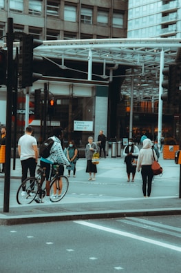 A person adjusting their urbantick watch while waiting at a busy crosswalk.