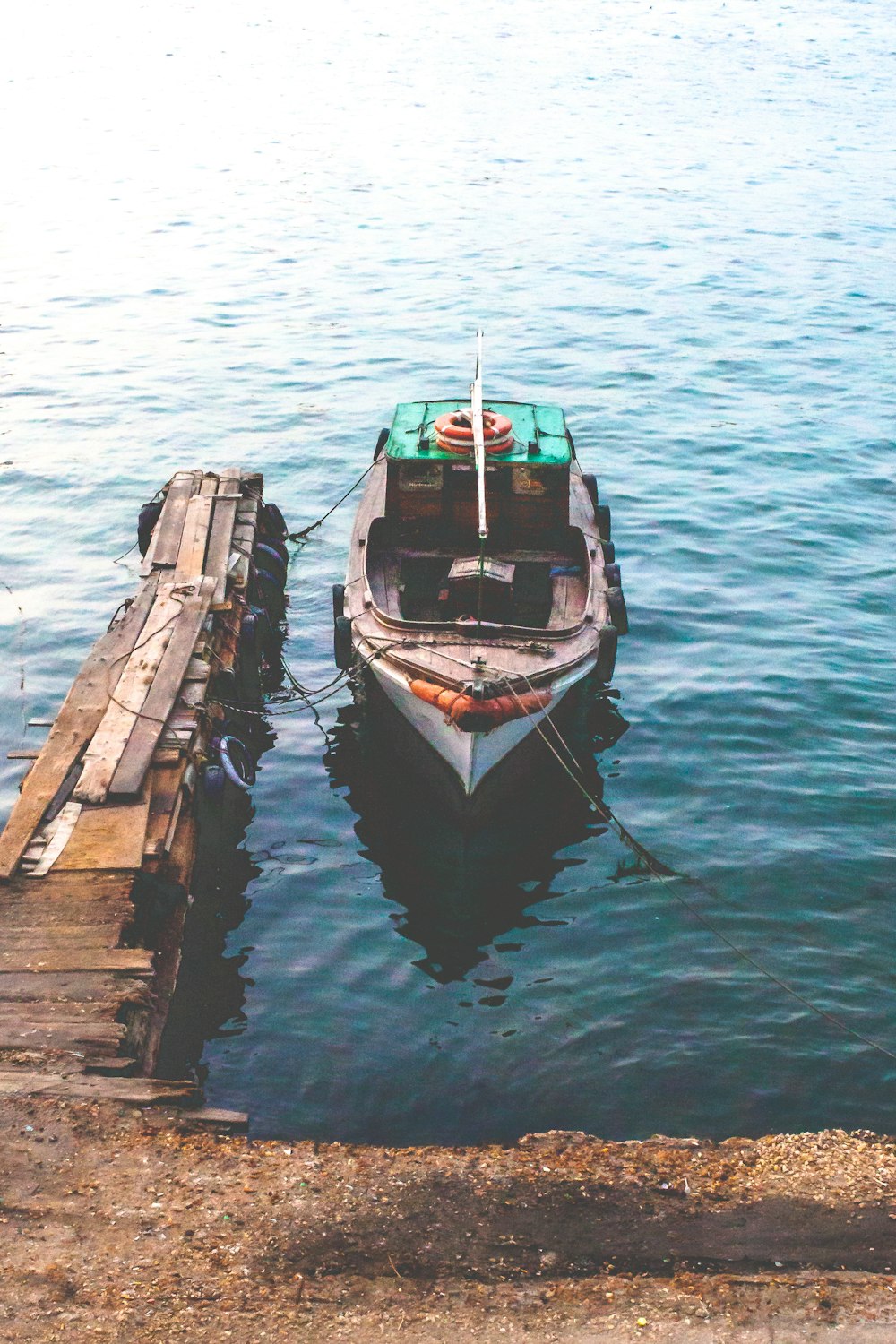 molo di legno marrone sullo specchio d'acqua durante il giorno