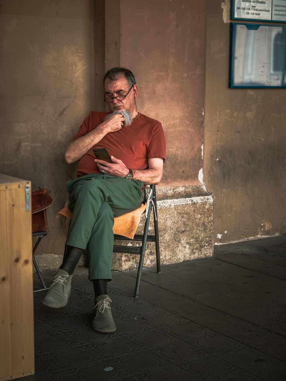 man in green polo shirt sitting on chair