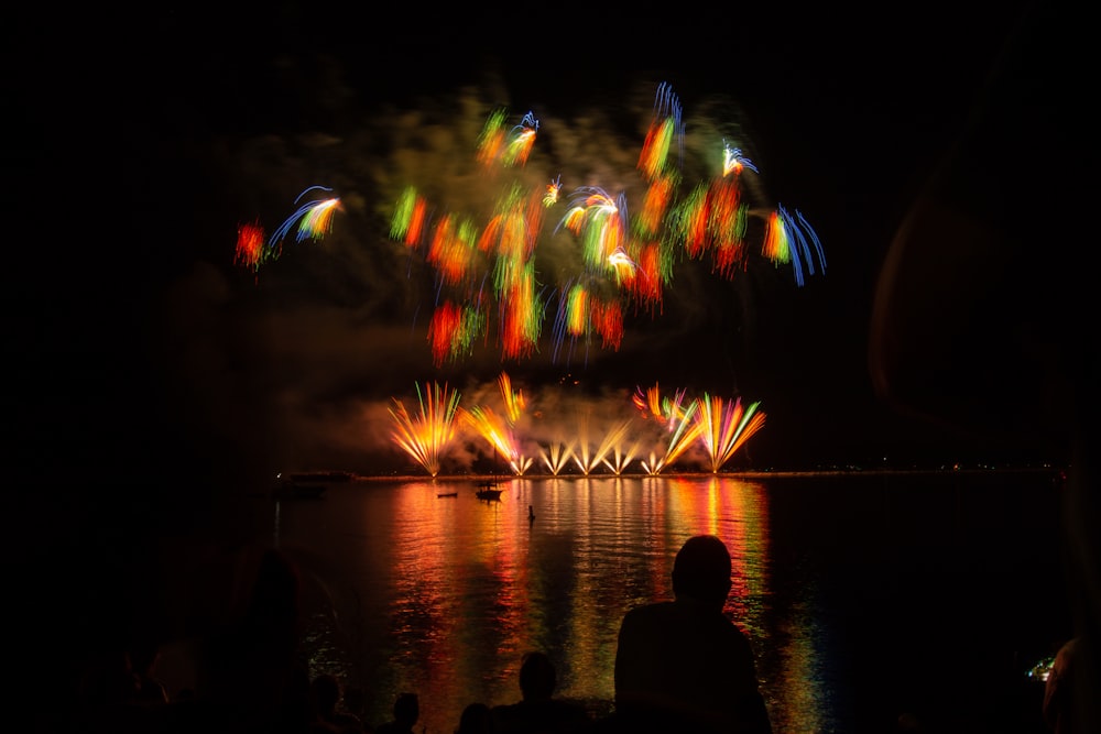 people watching fireworks display during nighttime