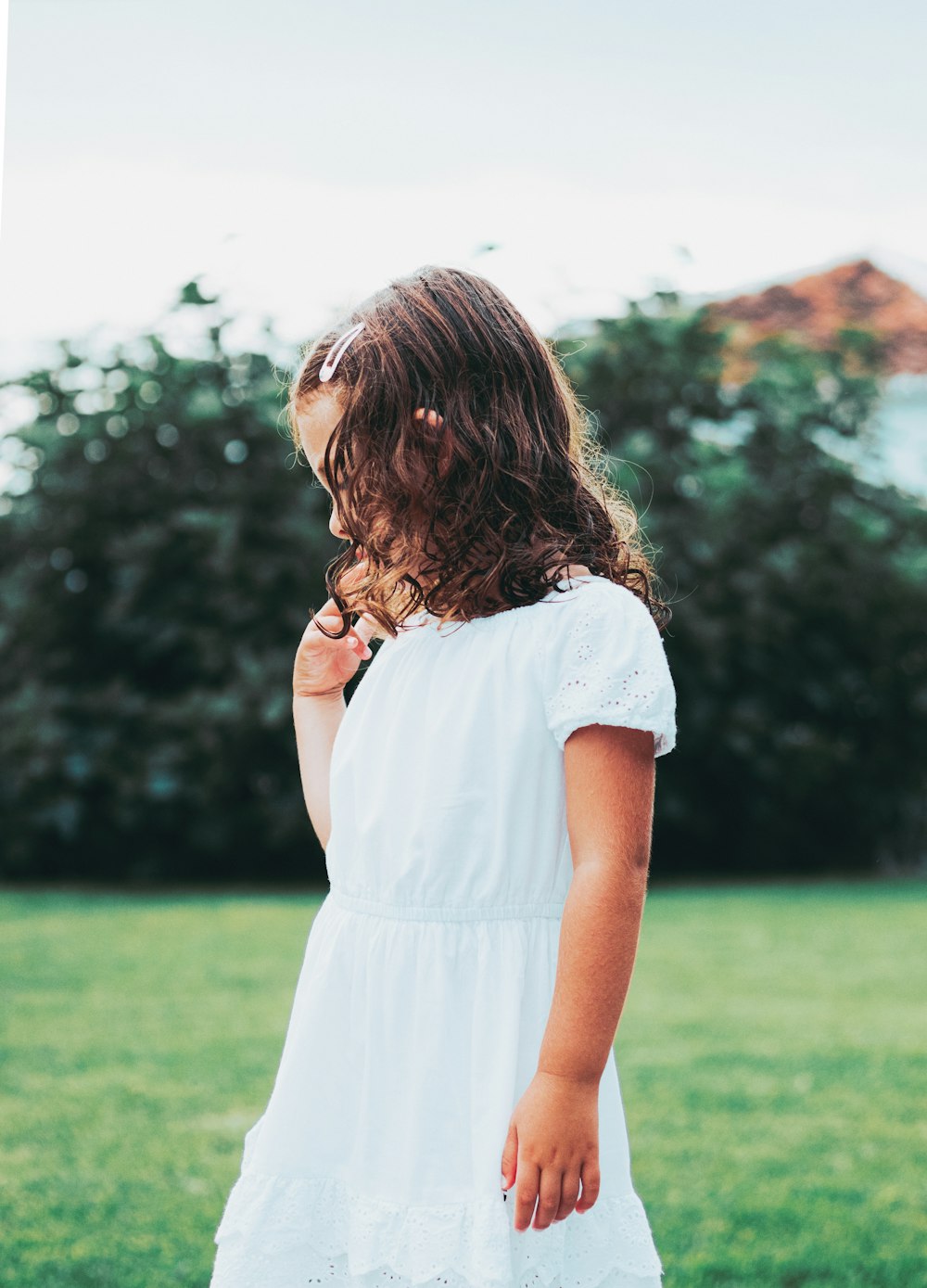 woman in white dress standing on green grass field during daytime