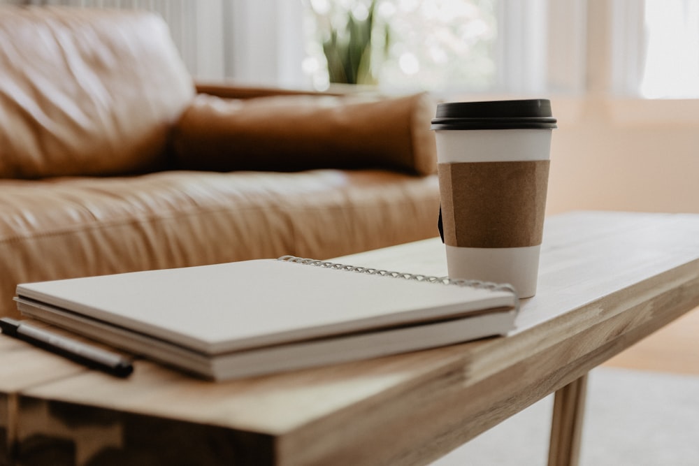 white and black coffee cup on white book page