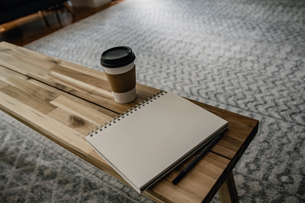 a cup of coffee sitting on top of a wooden table