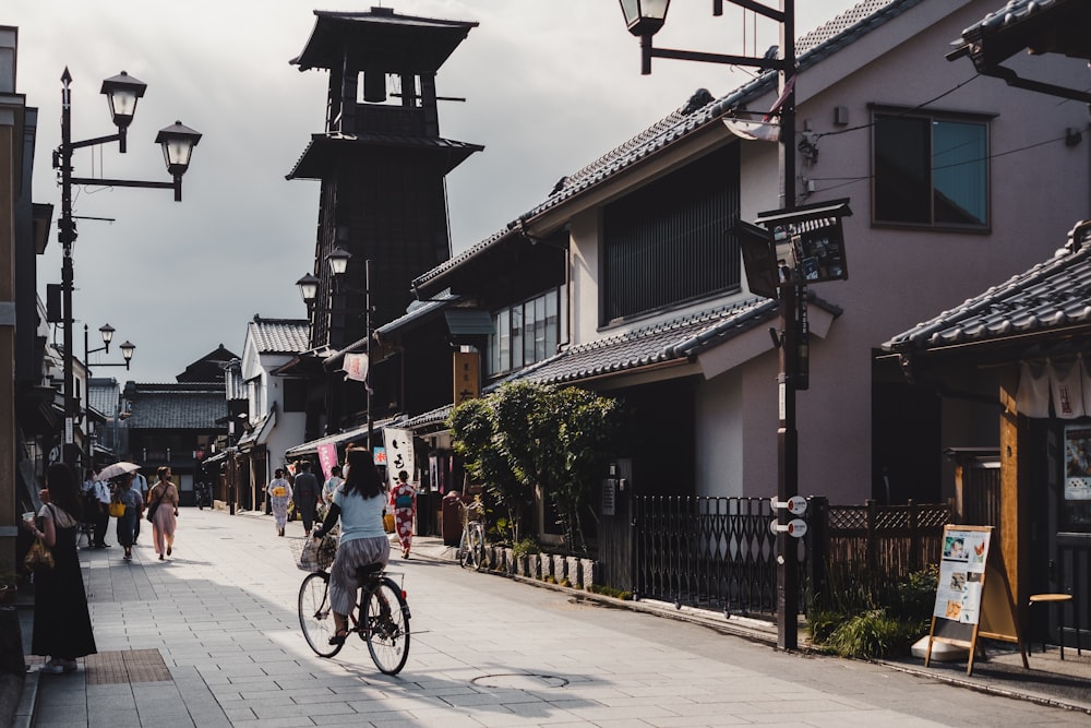 people riding bicycles on road near buildings during daytime