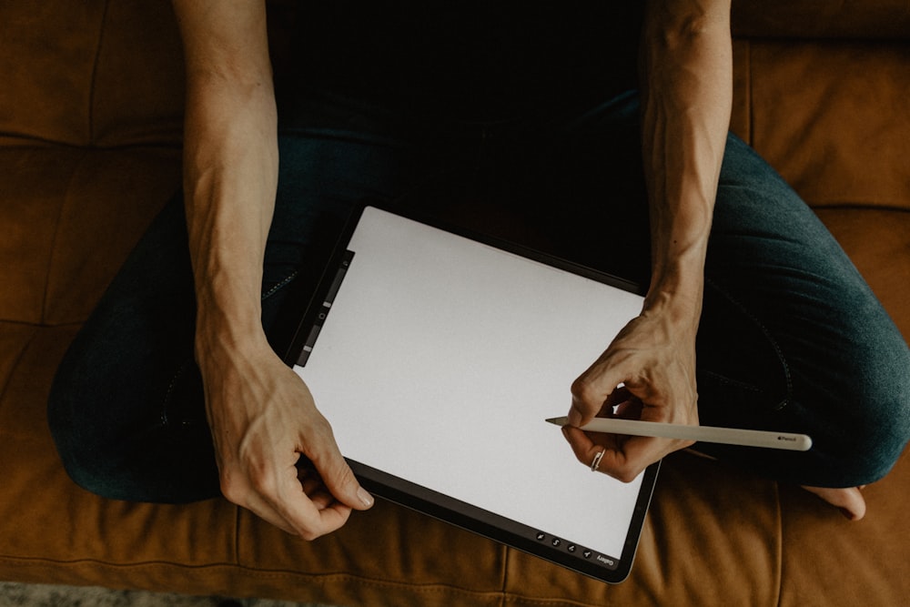 person holding white tablet computer