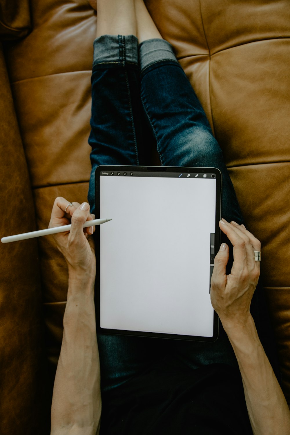 person holding white ipad on brown textile