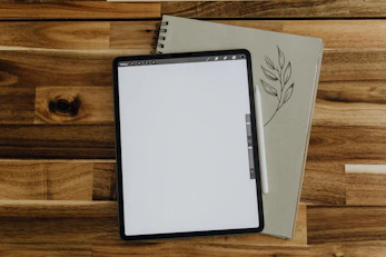 A tablet displaying notes with a stylus pen placed on top.