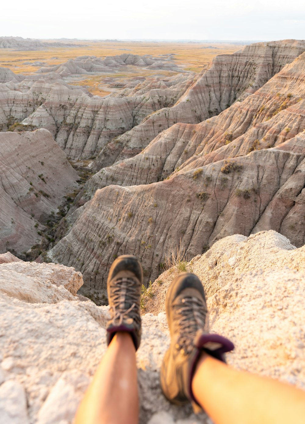 person in black and brown hiking shoes standing on rocky mountain during daytime