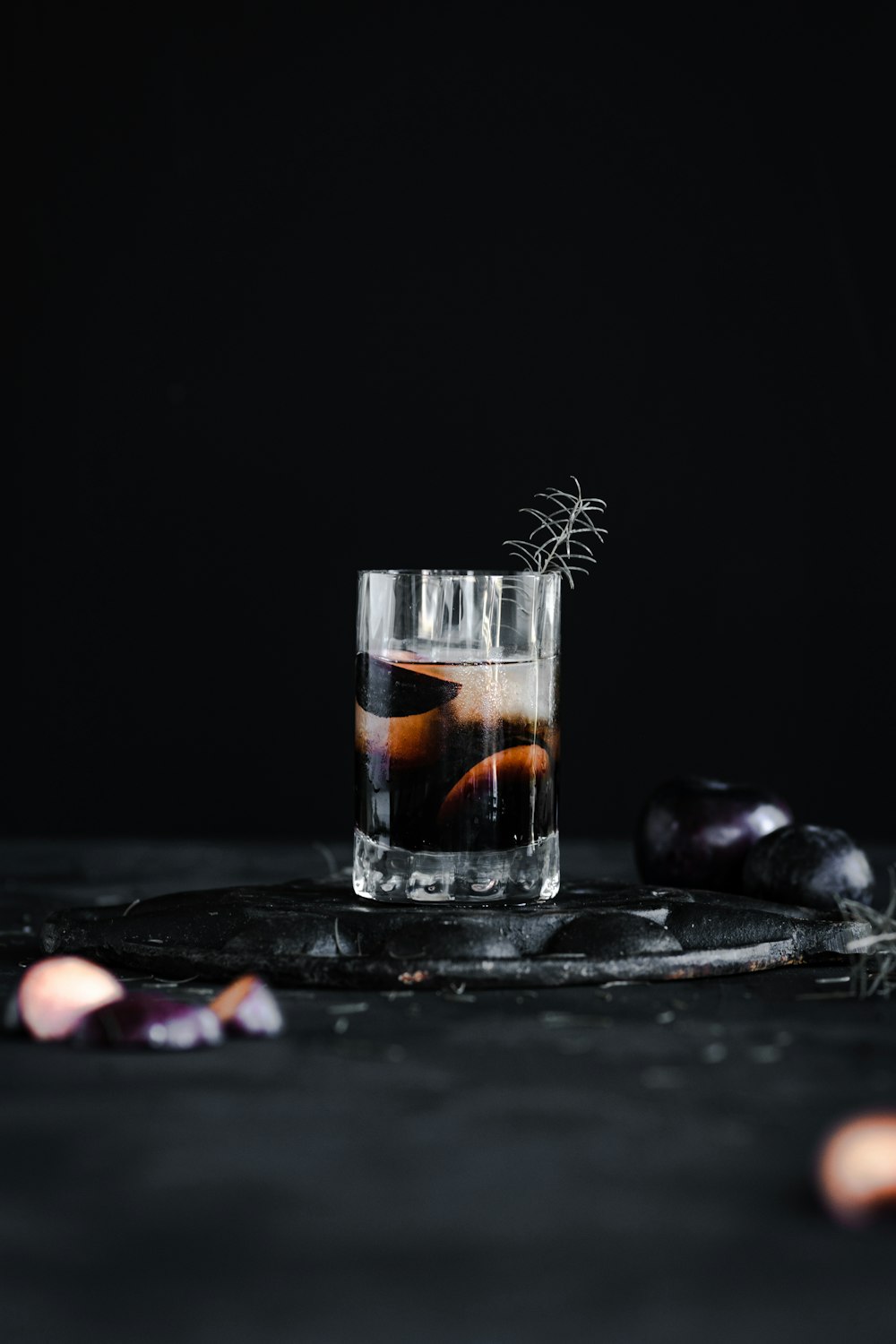 clear drinking glass with black liquid on black table