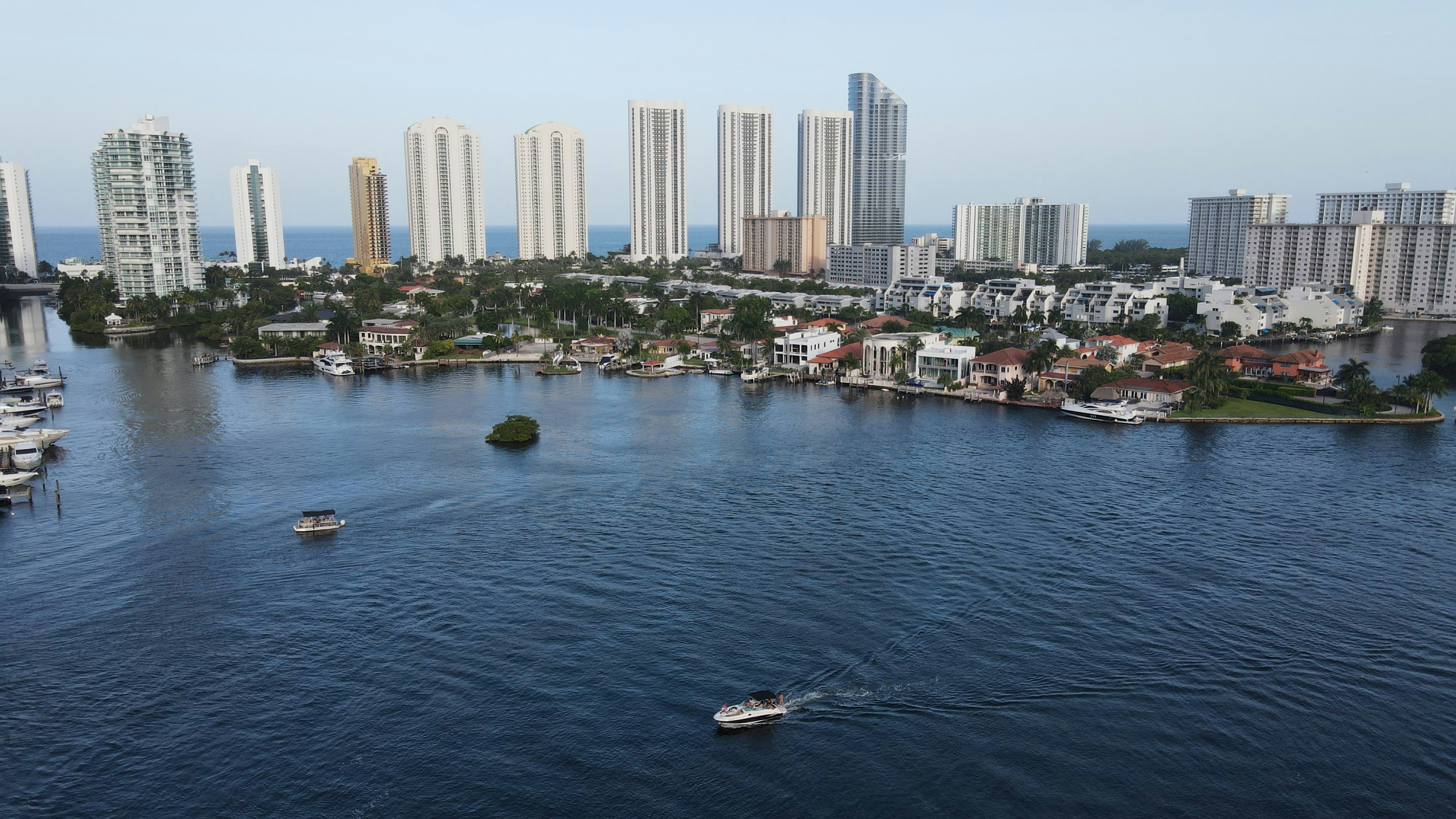 white boat on water near city buildings during daytime