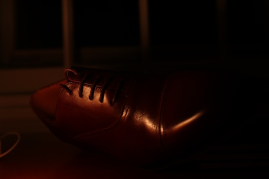 A refurbished leather shoe looking vibrant and polished under soft lighting on a clean background.