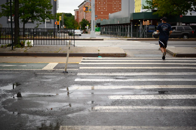 A runner jogging through a city street at dawn, with no visible shoe logos.