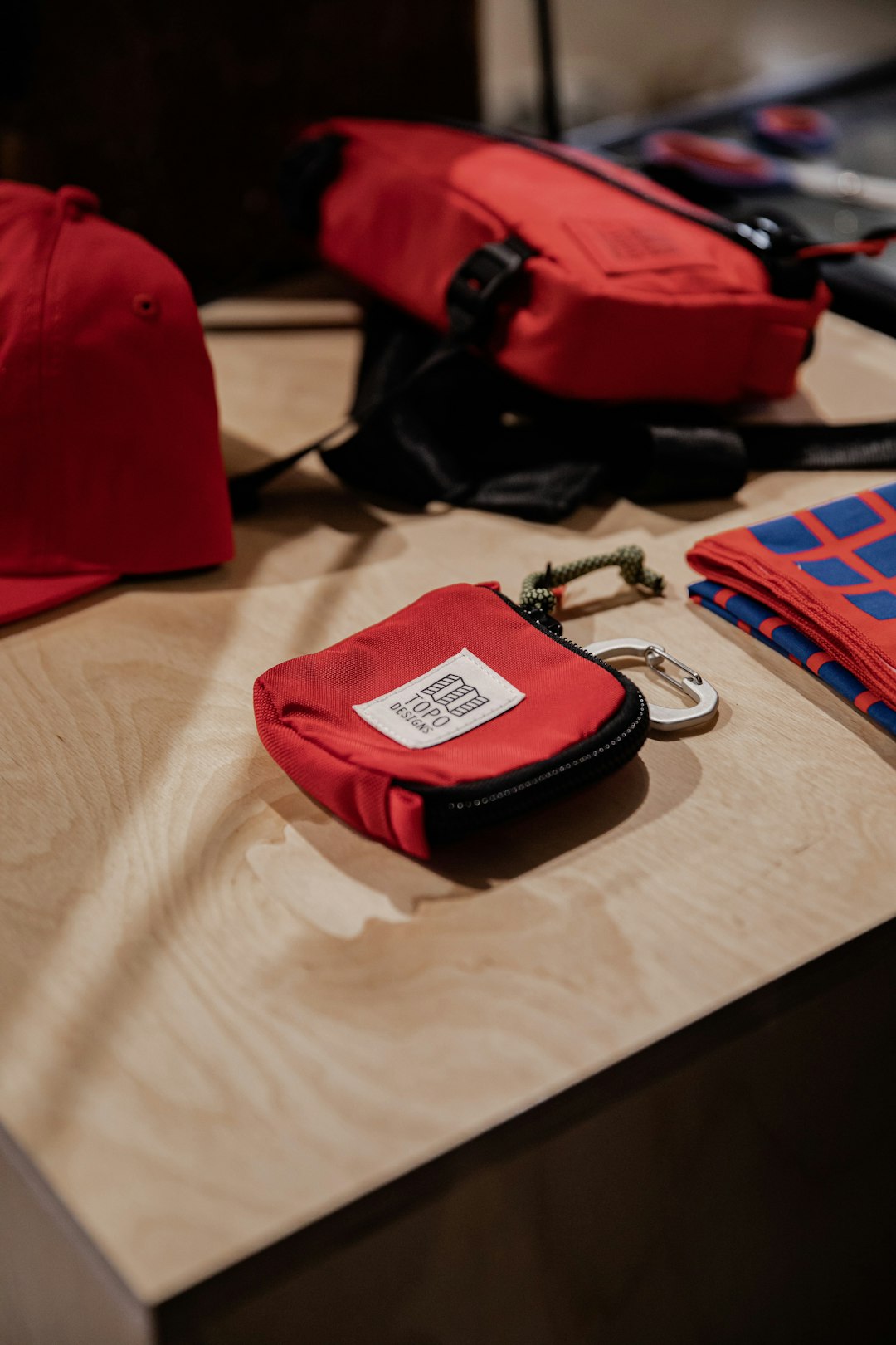 red and black leather sling bag on white textile