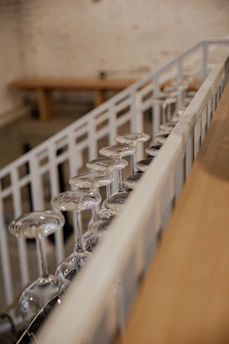 Close-up of wine glasses clinking during a tasting event in a rustic cellar