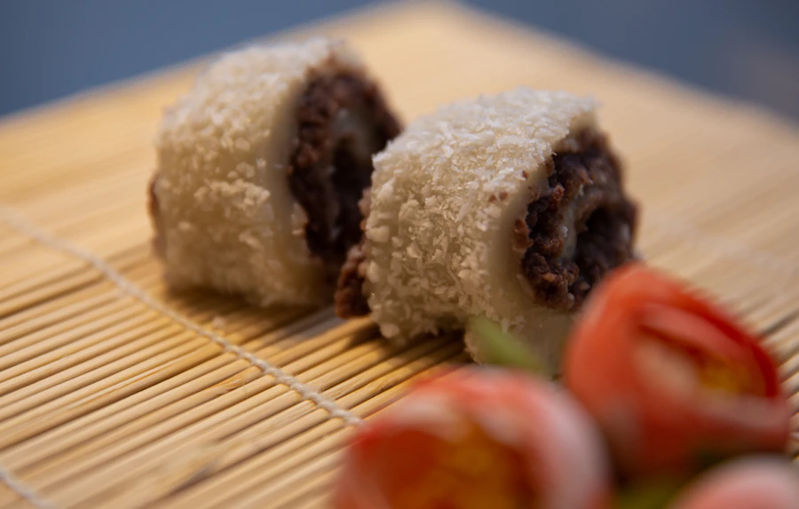 Two soft Korean rice cakes filled with sweet red bean on a bamboo mat