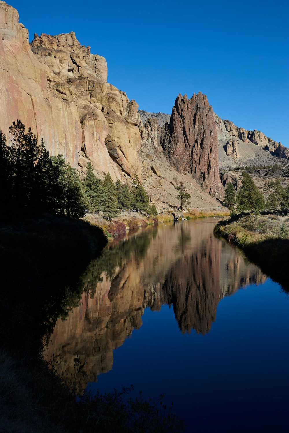 brown rocky mountain beside river during daytime