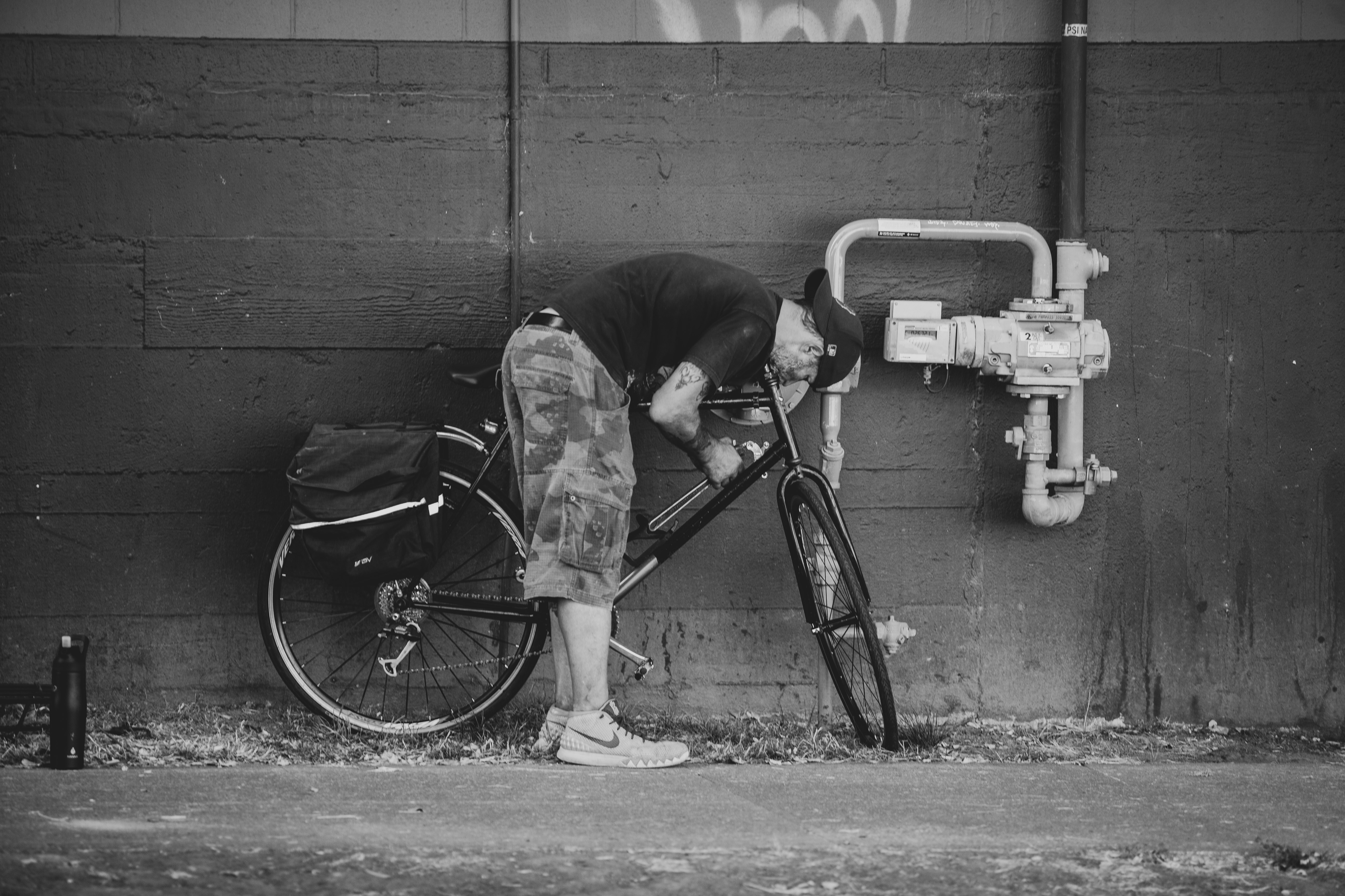 man in black jacket riding bicycle in grayscale photography