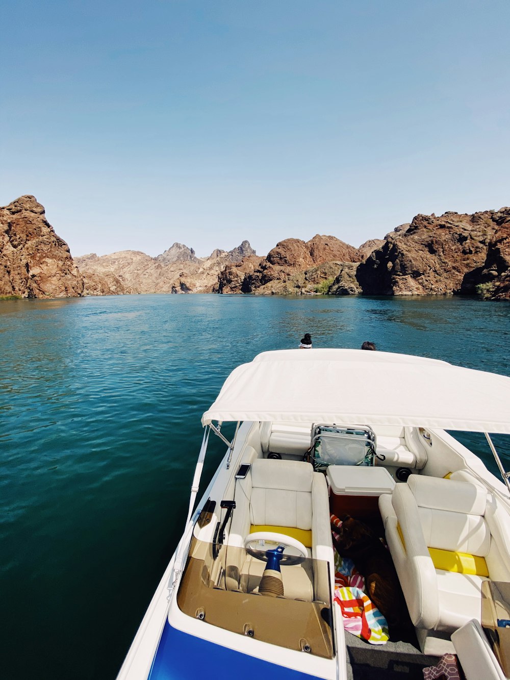 weißes und gelbes Boot auf blauem Meer tagsüber