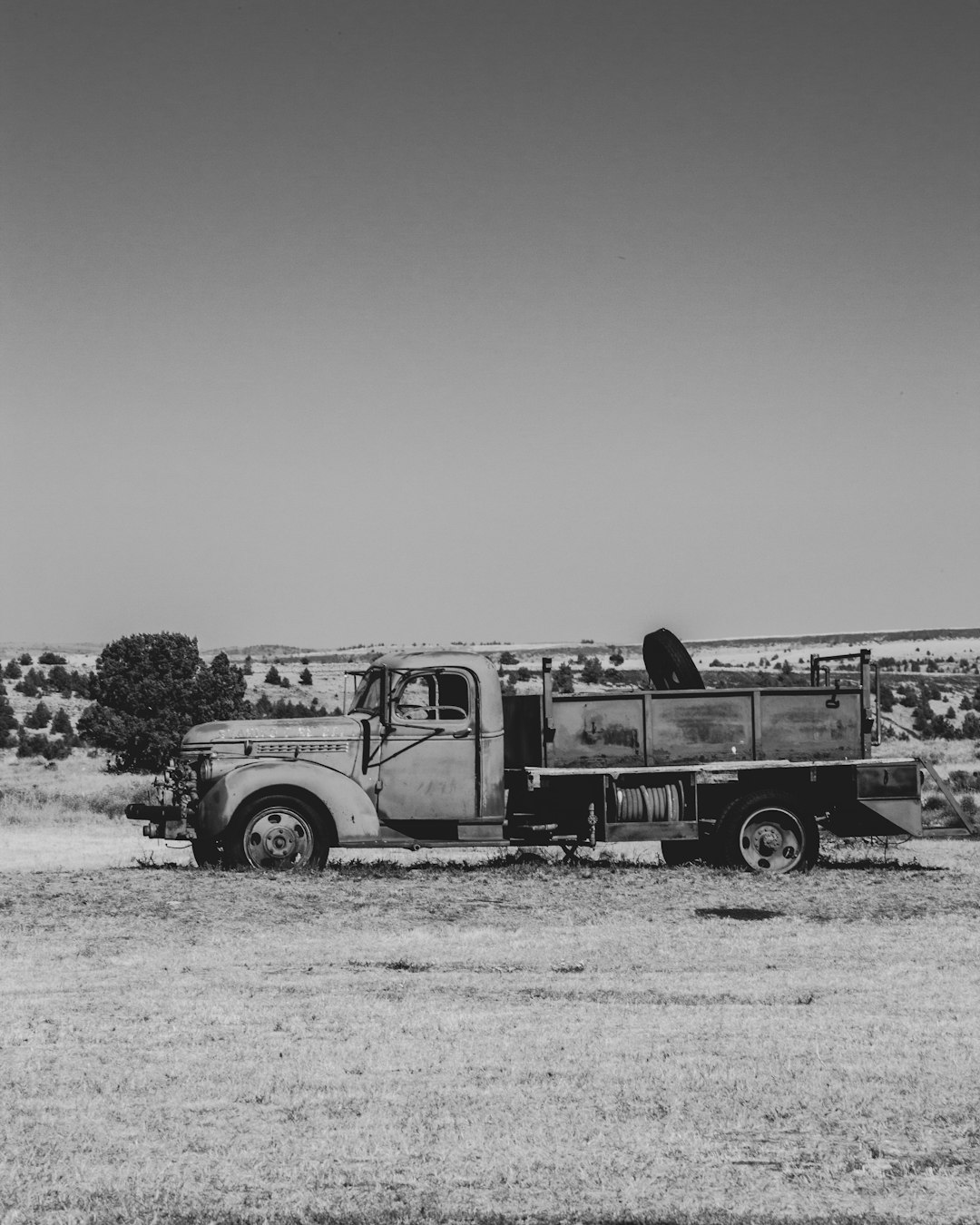 grayscale photo of vintage car on field
