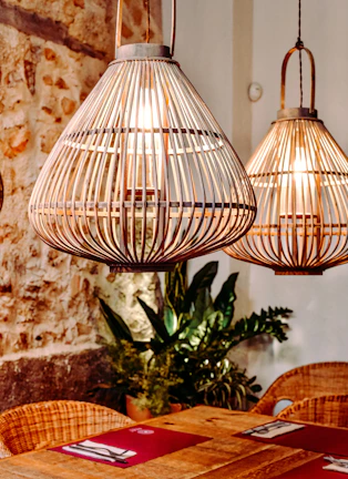 A bohemian macrame light hanging above a rustic wooden dining table, creating a relaxed vibe.
