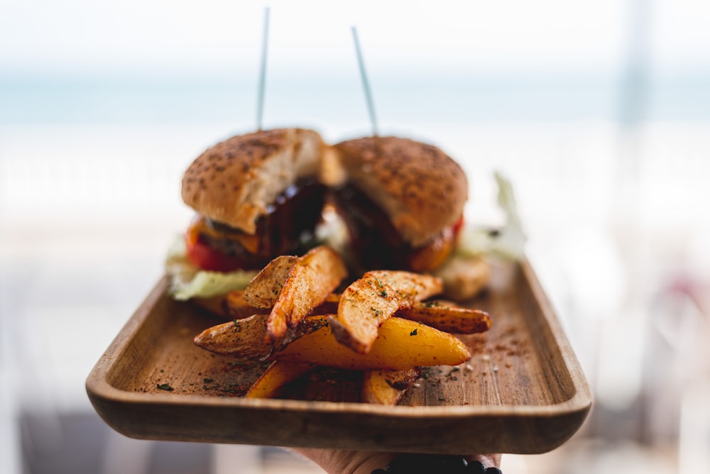 burger with patty and cheese on brown wooden tray