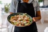 person holding green ceramic plate with food