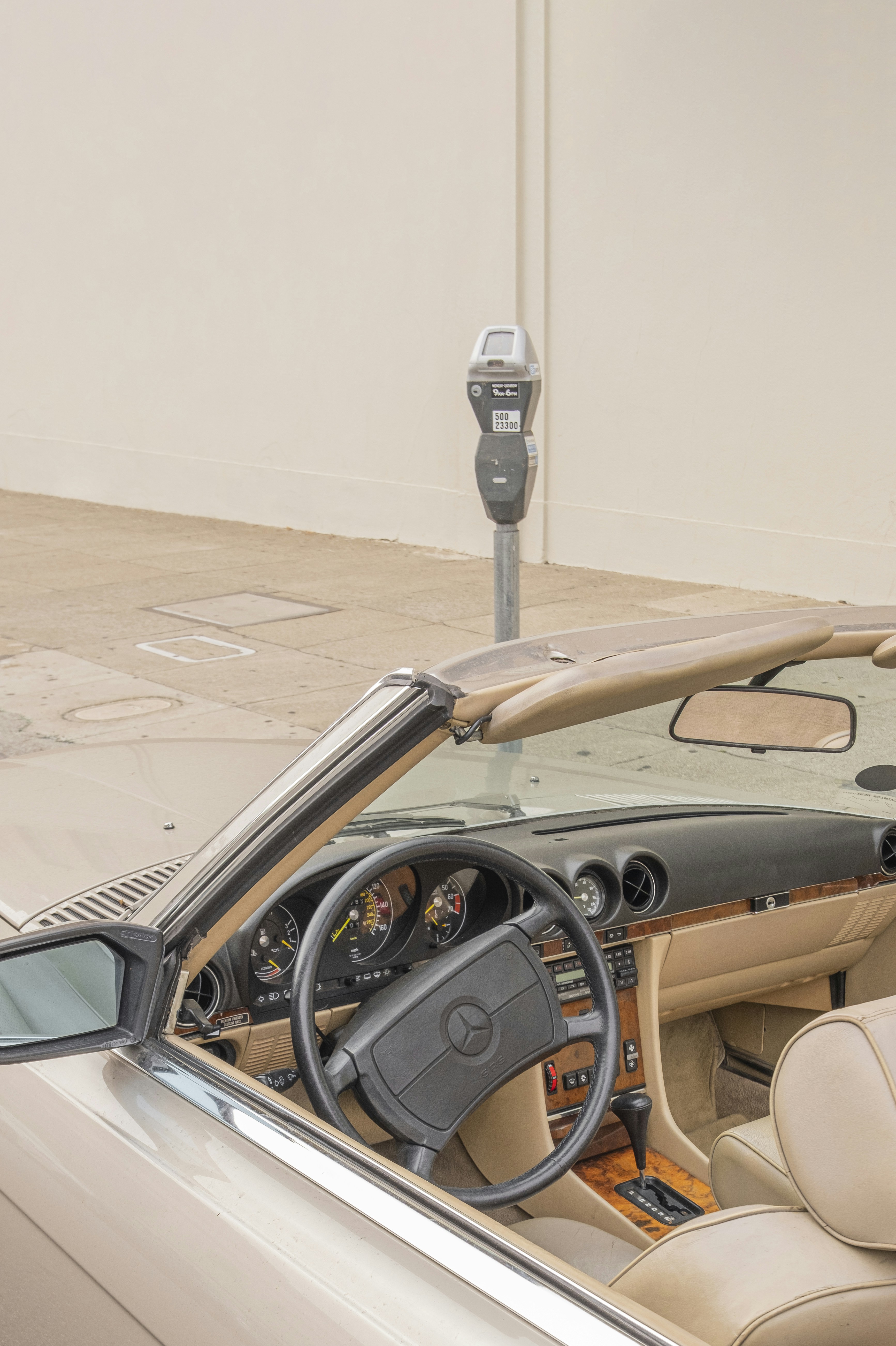 black and brown car in front of white wall