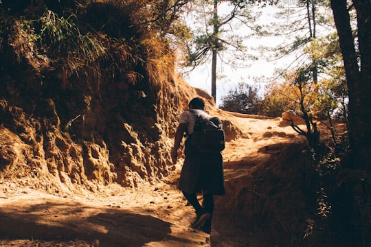 man and woman walking on brown dirt road during daytime in Paro Bhutan