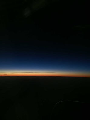 A deep, shadowed horizon where the ocean meets a darkening sky at sunset.
