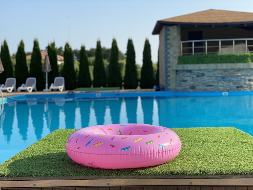 pink inflatable ball on green grass near swimming pool during daytime