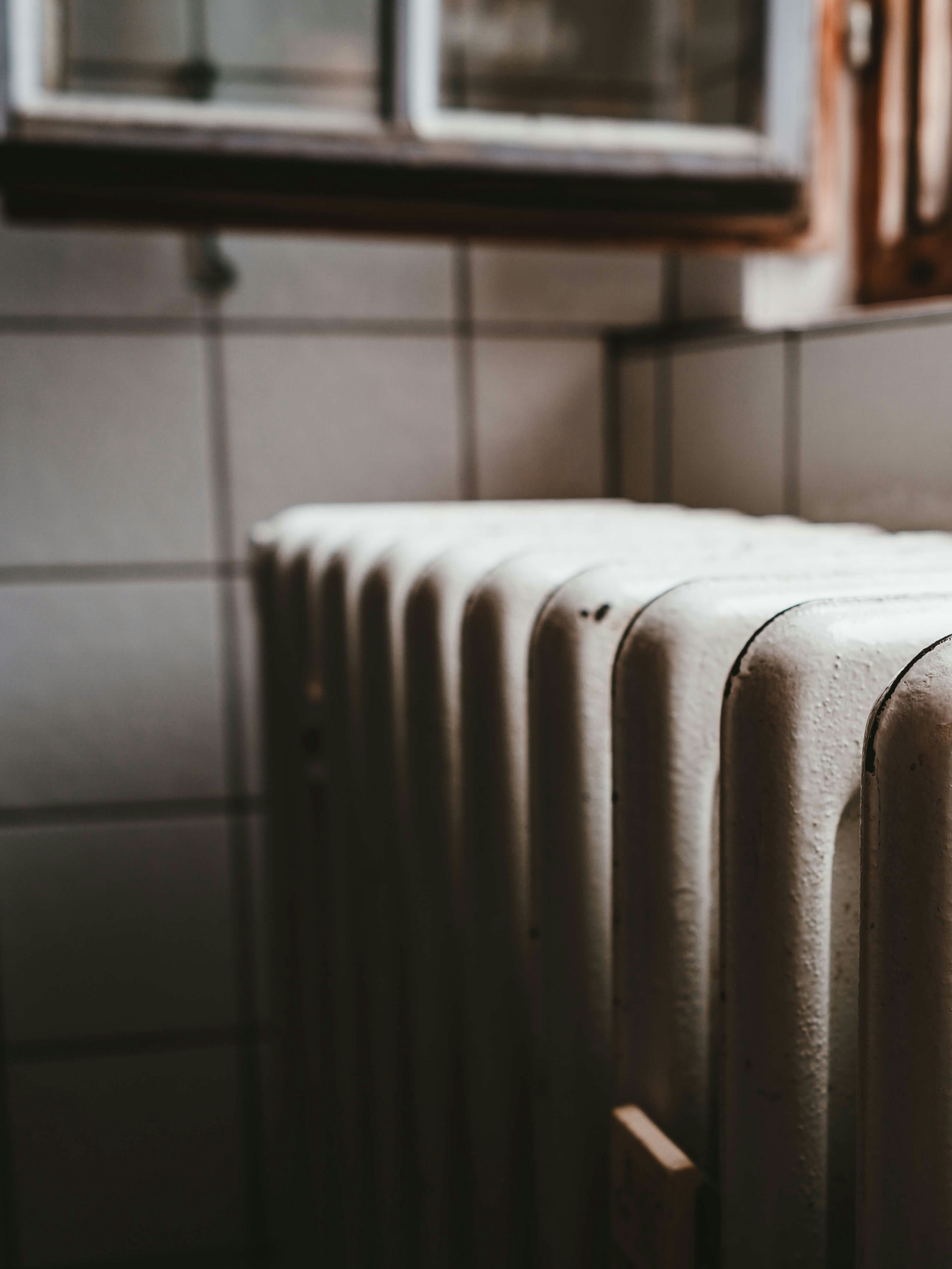 white radiator heater beside brown wooden window