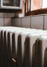 white radiator heater beside brown wooden window