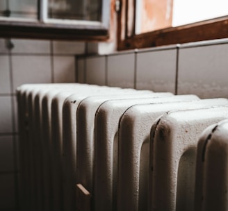 white radiator heater beside brown wooden window