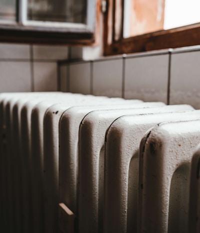 white radiator heater beside brown wooden window