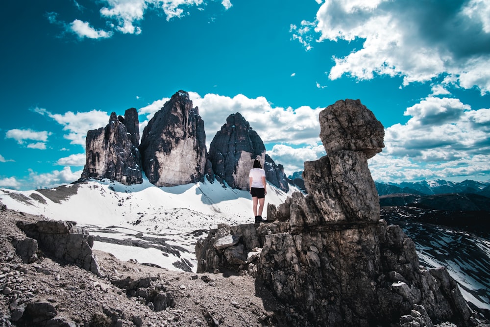 person standing on rocky mountain during daytime