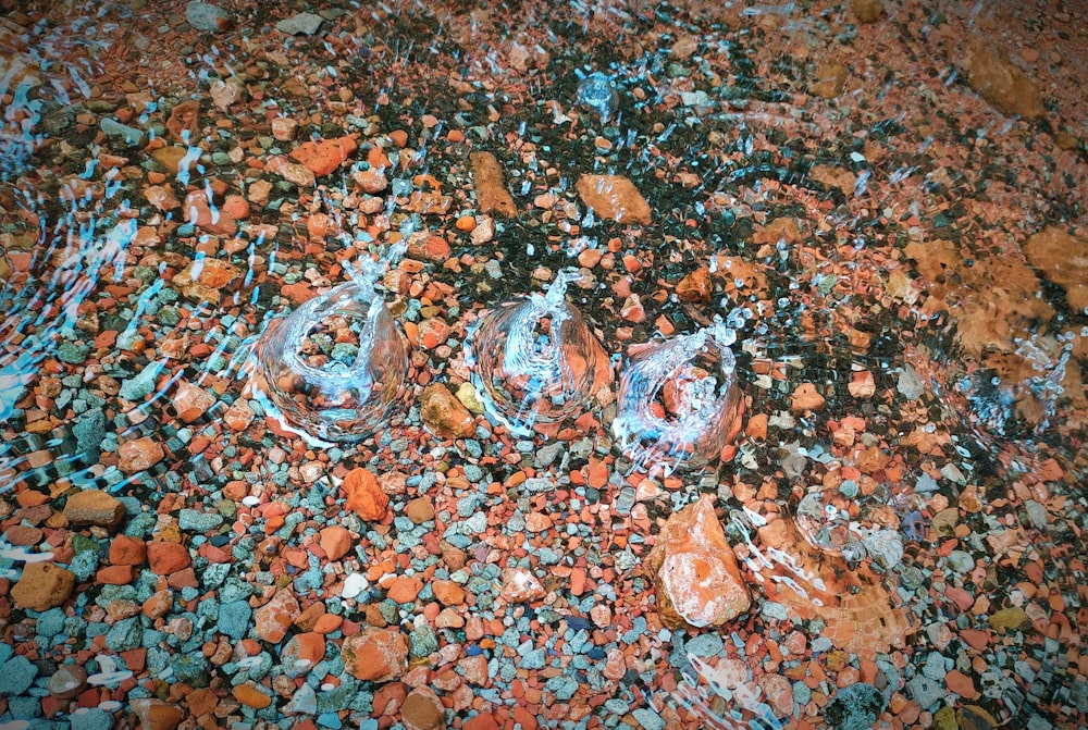 cinzeiro de vidro transparente em pedras marrons e pretas