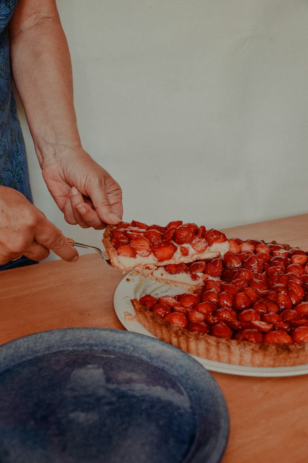 person holding red sliced fruit